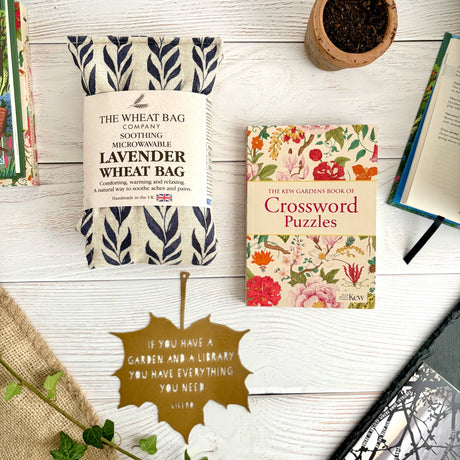 Garden Library Gift Set with Kew Gardens Crossword Puzzles, a Lavender Wheatbag and a Decorative Metal Leaf with choice of Quote imprinted. Flat lay on white wood background